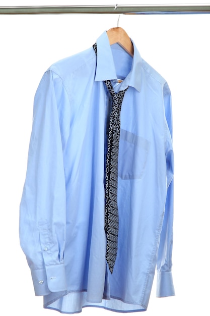 Camisa azul con corbata en percha de madera aislado en blanco