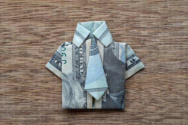 Camisa de origami feita de notas de dólar em fundo de madeira closeup nota de dólar tshirt