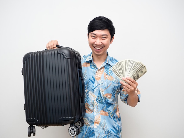 Camisa de praia jovem segura bagagem com muito dinheiro se sente feliz com o retrato de férias
