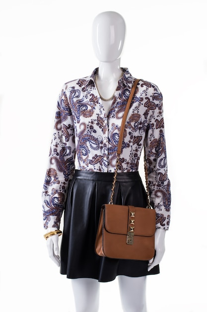 Camisa e bolsa no manequim. Camisa floral e acessórios femininos. Roupas de noite para meninas com bolsa. Joias preciosas e aparência elegante.