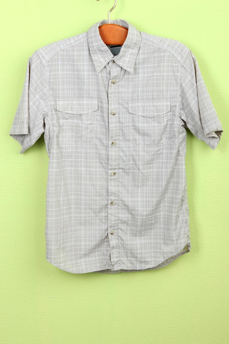 Foto camisa masculina em cabide de madeira no fundo da parede