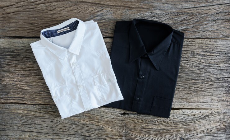 Camisa negra y camisa blanca sobre fondo de madera