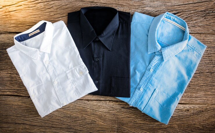 Camisa negra, camiseta blanca y camisa de jeans en fondo de madera