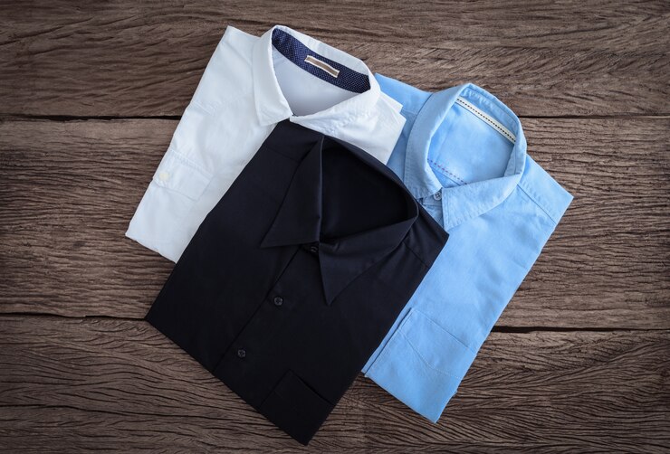 Camisa negra, camiseta blanca y camisa de jeans en fondo de madera