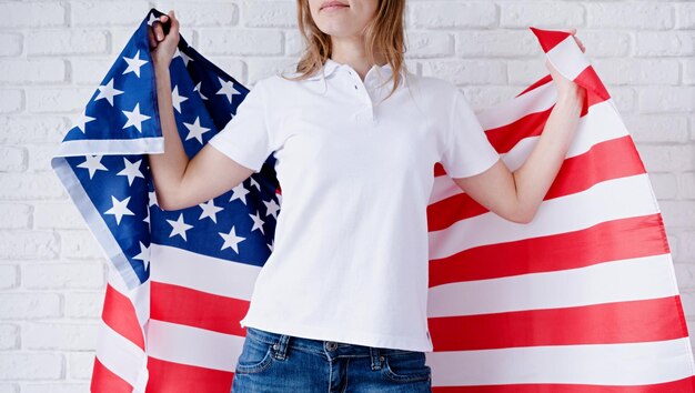 Camisa polo branca em mulher sobre design de maquete de fundo de bandeira dos EUA