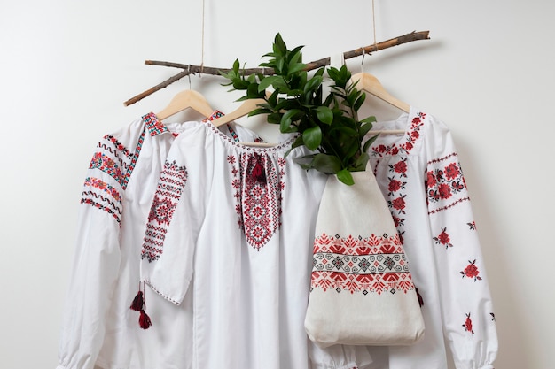 Foto camisas bordadas e bolsa em cabides