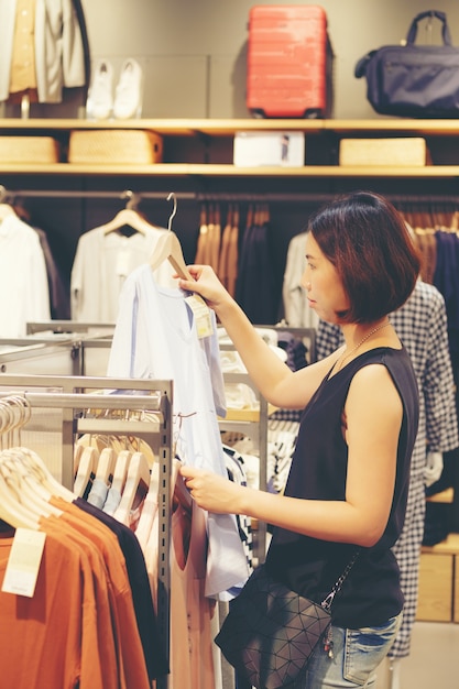 Camisas de compras hermosas de la muchacha de Asia de la mujer tailandesa en superstore