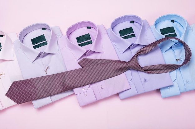 Camisas y corbatas masculinas multicolores en un concepto de fondo rosa sobre el tema de combinar una corbata