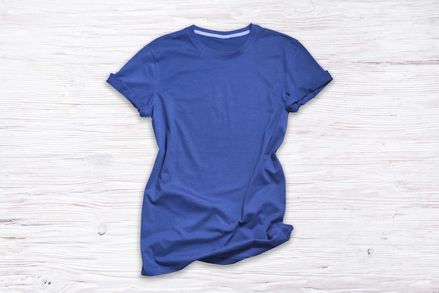 Camiseta de algodón azul sobre fondo de madera,