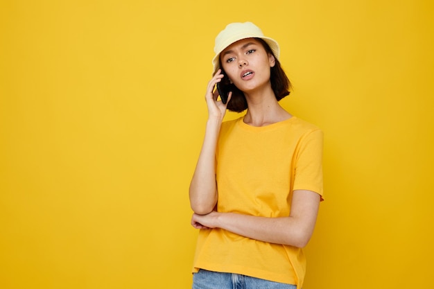 Camiseta amarela jovem otimista e estilo de verão chapéu com telefone Estilo de vida inalterado