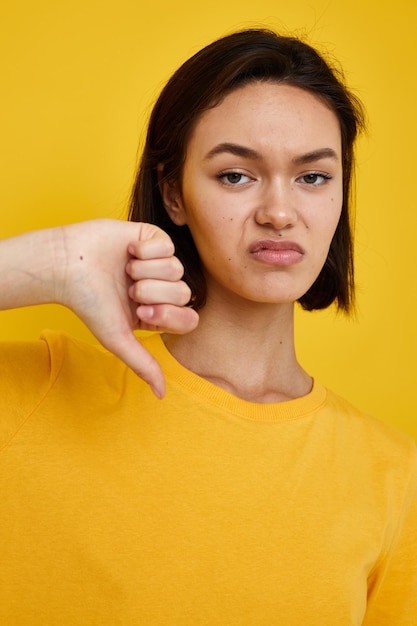 Camiseta amarela morena de cabelos curtos estilo de verão gesto de mão fundo amarelo