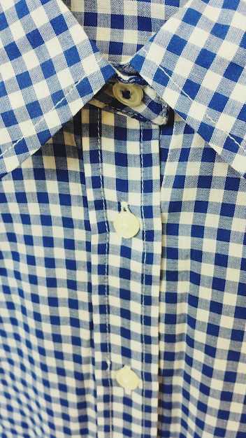 Foto camiseta azul a cuadros colgando en el estante de la tienda