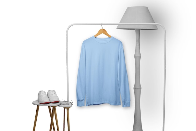 Camiseta azul de manga larga en percha de madera colgada en la pantalla del estante