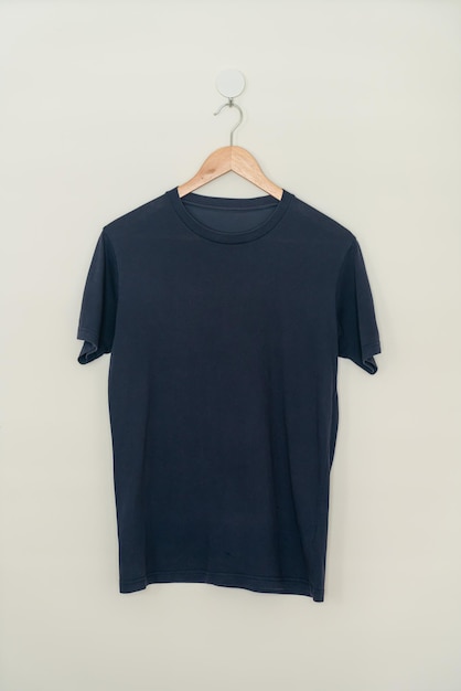 camiseta azul marino colgada con un colgador de madera en la pared