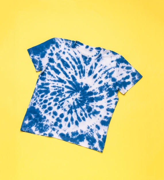 Camiseta azul con un patrón en espiral en estilo tie dye sobre un fondo amarillo Lay Flat