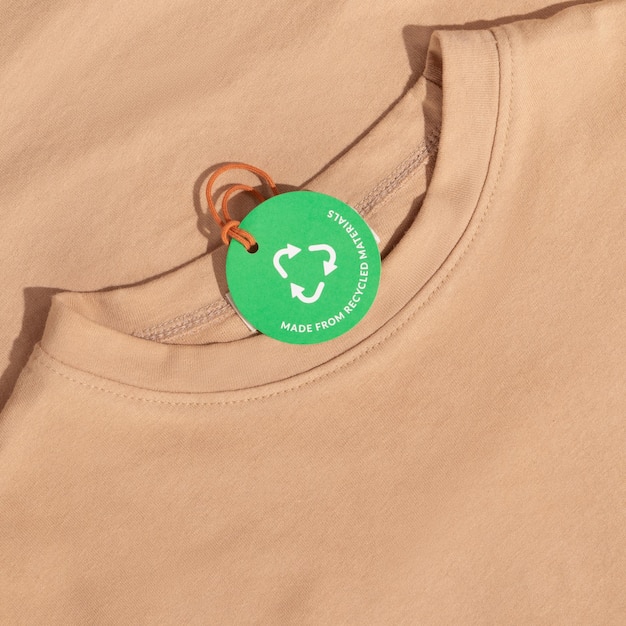 Camiseta bege e etiqueta de papel com inscrição Feito de materiais reciclados Conceito de ecologia Mockup