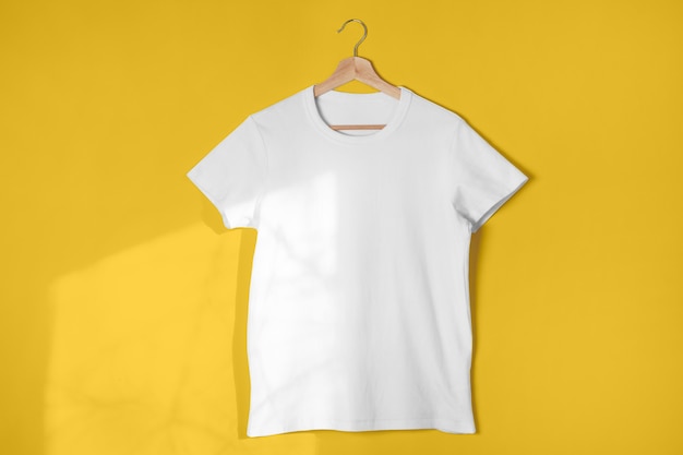 Camiseta blanca en blanco contra amarillo claro