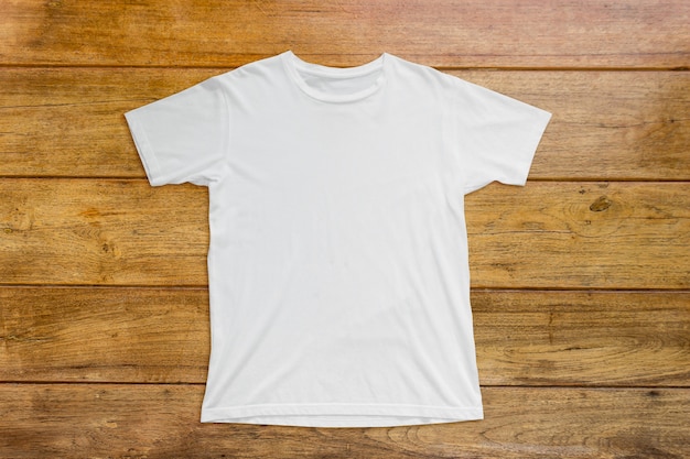 Foto camiseta blanca sobre suelo de madera