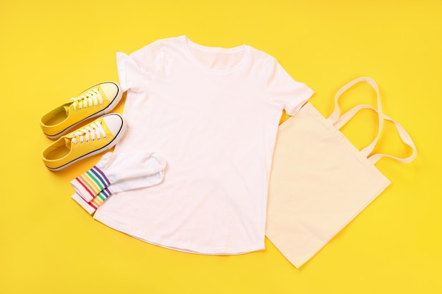 Camiseta, bolso, calcetines y zapatillas en blanco sobre fondo amarillo