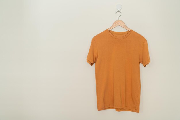 camiseta colgada con percha de madera