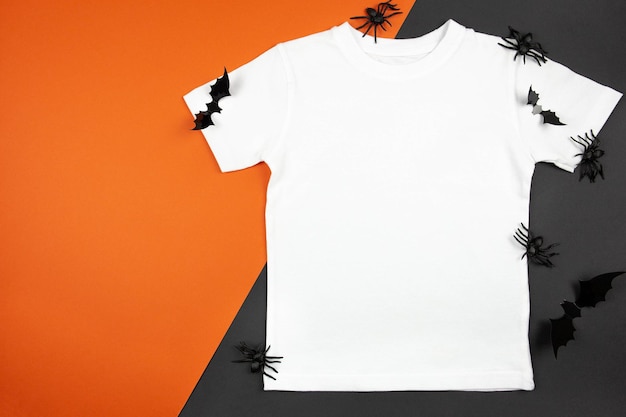 Camiseta de algodão feminina branca maquete de halloween com aranhas e morcegos em fundo laranja preto design modelo de camiseta impressão apresentação mock up vista superior plana leiga