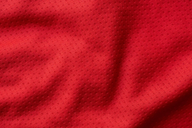 Camiseta de fútbol de ropa deportiva de tela roja con fondo de textura de malla de aire