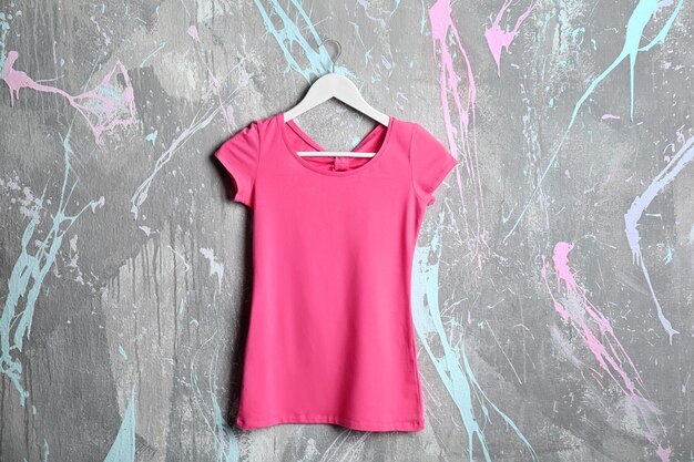 Camiseta rosa en blanco sobre fondo grunge