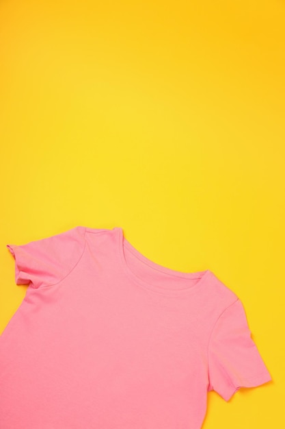 Camiseta rosa em branco com espaço para impressão em fundo amarelo