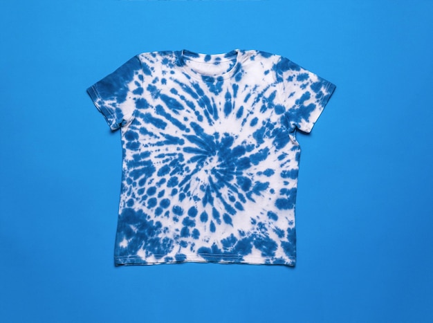 Camiseta tie dye blanca y azul sobre fondo azul Lay Flat