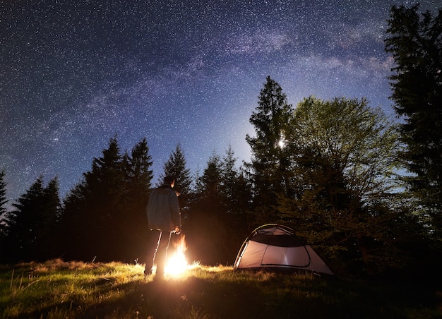 Campamento nocturno en las montañas bajo el cielo estrellado y la vía Láctea.