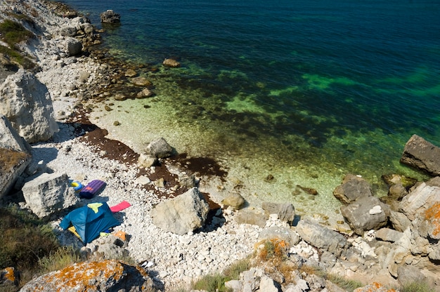 Campamento de tiendas de campaña en la costa rocosa del mar.