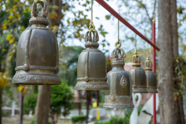 Campana grande que cuelga campanas de estilo tailandés tradicional en el enfoque selectivo del templo