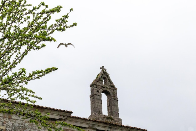 Campanario de una iglesia de piedra con una campana en el campanario