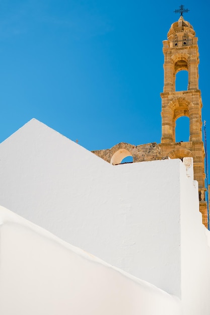 El campanario de la Iglesia de la Santísima Virgen en Lindos en un día soleado disparó verticalmente las islas del archipiélago del Dodecaneso en Grecia Europa vacaciones y tiempo de viaje