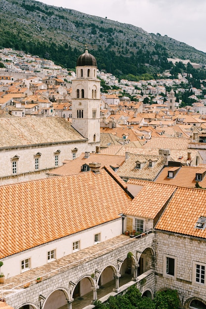 El campanario del monasterio franciscano de dubrovnik con el telón de fondo de los tejados de la