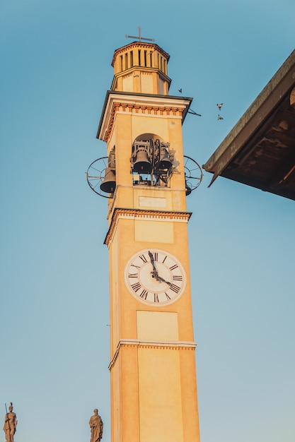 El campanario con un reloj de la antigua catedral medieval en la hora del atardecer. Hermosa iglesia italiana. San Paolo. Chiesa di Santa Maria Nascente