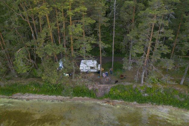 Foto camper se encuentra cerca del bosque y el lago.