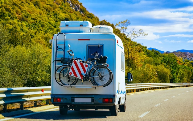 Camper mit Fahrrad unterwegs bei Buggerru in Carbonia-Iglesias auf der Insel Sardinien, Italien Sommer. Wohnwagen Wohnmobil im Urlaub an der Autobahn. Minivan Wohnmobil auf der Autobahn. Provinz Cagliari. Gemischte Medien.