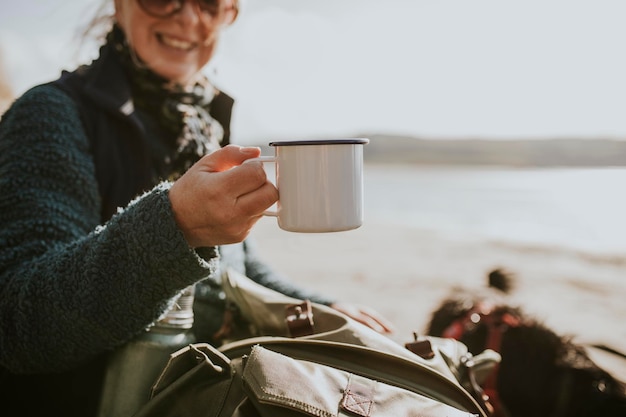 Camper mujer senior sosteniendo una taza de café con espacio de diseño