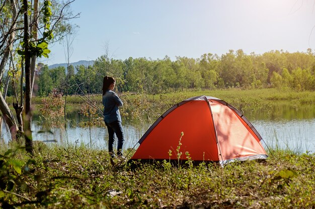 Camping en un bosque. Escena de la mañana con la tienda de campaña en el bosque verde cerca del lago