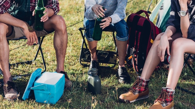 Camping camp in der natur glückliche freunde gruppe trinken bier im sommer im naturwald