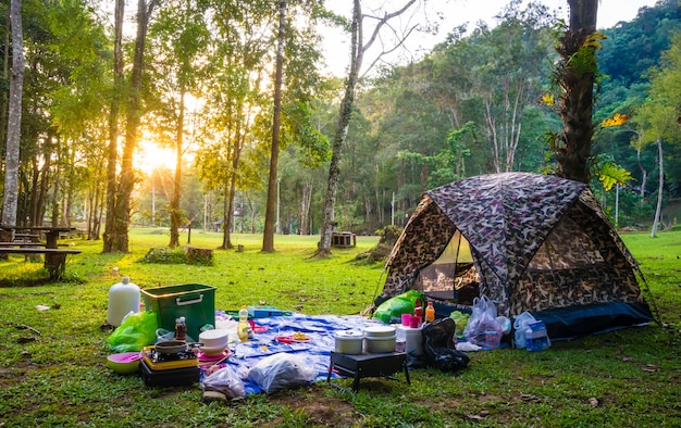 Camping y carpa con puesta de sol en parque natural.