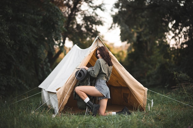 Camping con carpas Chica joven sexy viaja con una mochila La chica en el fondo de la carpa