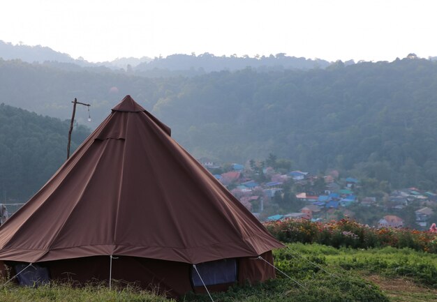 Camping en la colina con niebla ligera en el fondo del paisaje de la naturaleza de la puesta del sol