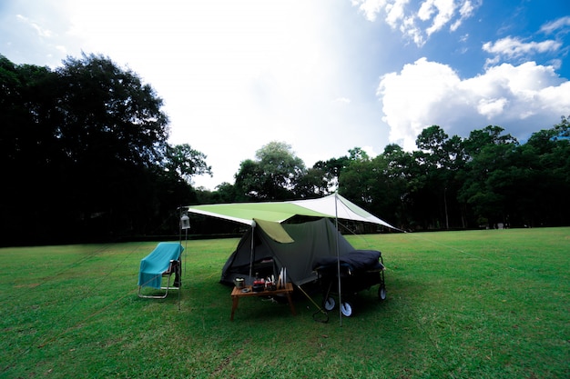 Camping e barraca na grama verde na floresta na montanha