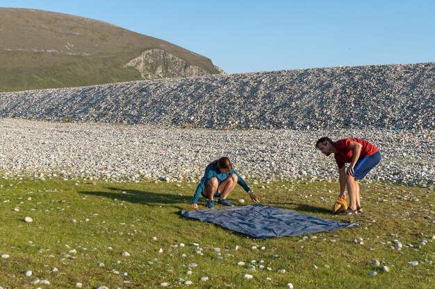 Camping-Leute im Freien Lifestyle-Paar, das ein Zelt am felsigen Strand der Natur aufstellt.