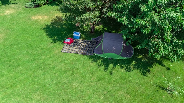 Camping-Luftbild von oben Zelt und Campingausrüstung unter Baumfamilienurlaub im Camp im Freien Konzept