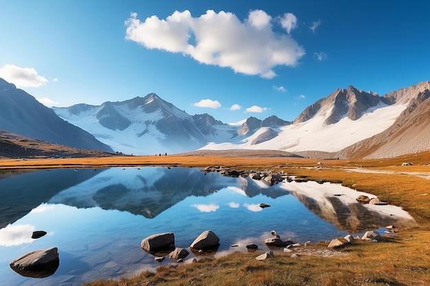 Camping mit Zelt in der Nähe eines hochgelegenen Sees in den Alpen Spiegelung der schneebedeckten Bergkette und landschaftlicher