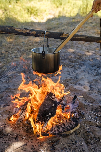 Camping, una olla de agua hierve sobre el fuego.