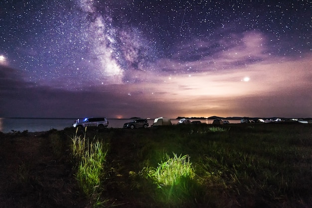 Camping en la playa del mar bajo el cielo nocturno.